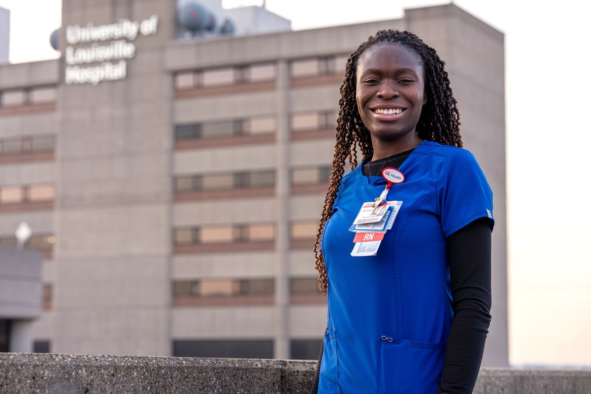 Faith Akinmade, an ICU nurse at the University of Louisville (Kentucky) Hospital, who is originally from Nigeria, poses Tuesday in front of the hospital. After completing college in the United States, Akinmade has been working at the hospital, but her work permit is set to expire in March and she said she needs it renewed, or her green card approved, to stay on the job. (Tom Round)