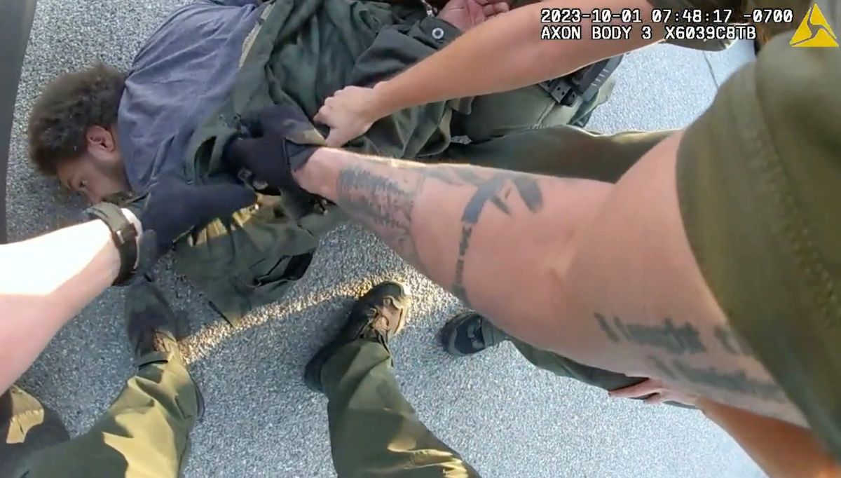 Seen in the police body camera video, Joshua Clark is restrained on the ground after being pulled out of the driver’s seat of his car by Spokane Valley Deputy Samuel Turner in October of 2023 while police were looking for another person. Clark has filed a lawsuit over the arrest and charges of resisting arrest were later dropped. (Jesse Tinsley/THE SPOKESMAN-REVIEW)