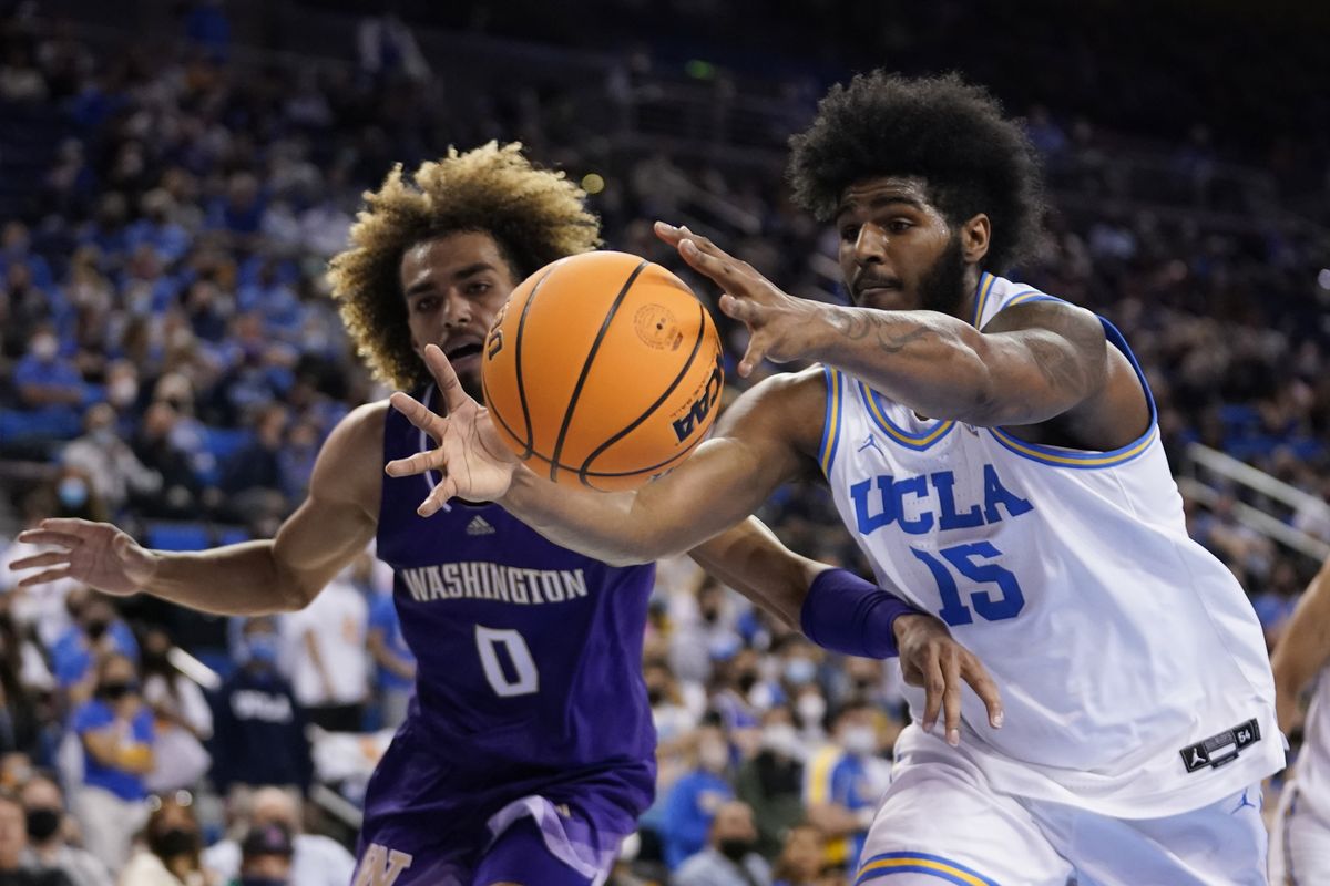 UCLA center Myles Johnson (15) grabs a rebound next to Washington forward Emmitt Matthews Jr. (0) during the first half of an NCAA college basketball game Saturday, Feb. 19, 2022, in Los Angeles. (Marcio Jose Sanchez)
