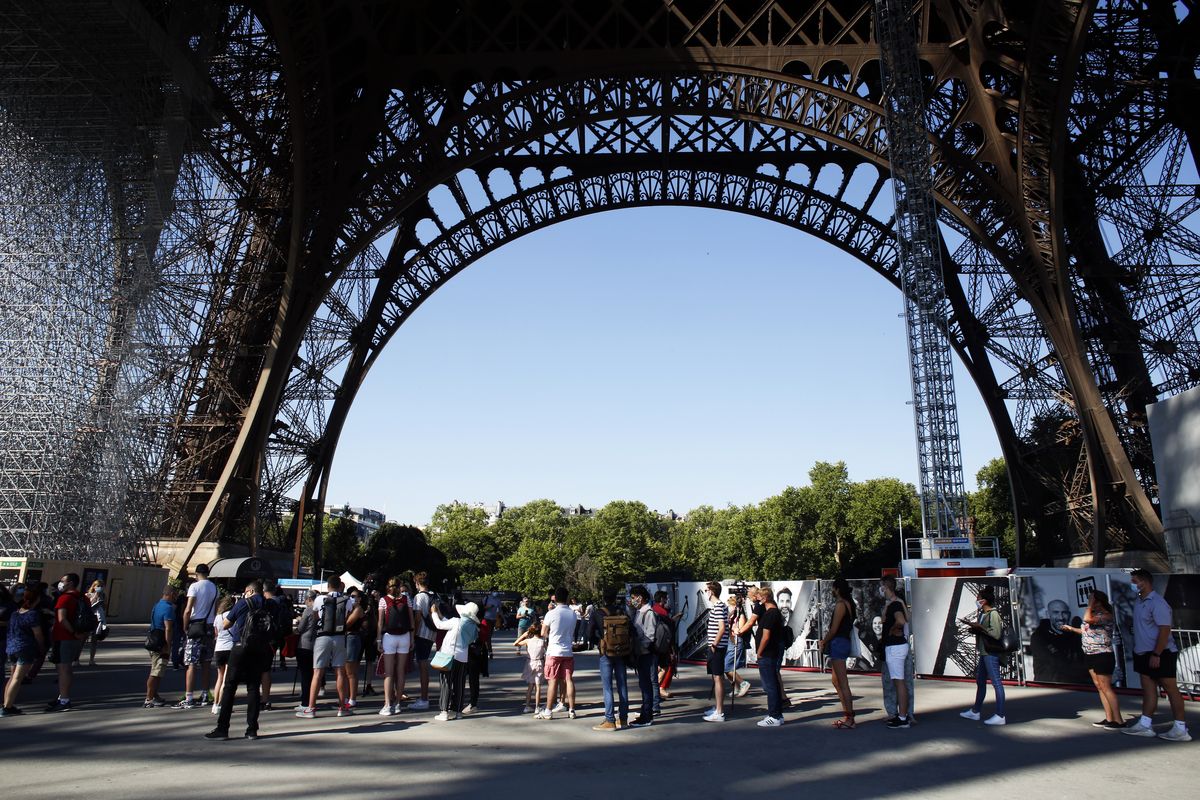 People queue up prior to visit the Eiffel Tower, in Paris, Thursday, June 25, 2020. The Eiffel Tower reopens after the coronavirus pandemic led to the iconic Paris landmark