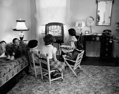 In this Jan. 6, 1953, photo, four schoolchildren watch a teacher give them a lesson via television at home in Baltimore, Md. TV was key to the world baby boomers were born into: a modernized world whose problems all seemed to have available solutions. (Anonymous / Associated Press)