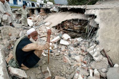 
Faridullah squats over the debris after his  house in Abbotabad, Pakistan, collapsed Saturday during a powerful earthquake.
 (Associated Press / The Spokesman-Review)