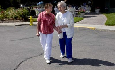 
Elsie Dial, left, and Jeanette Gettig walk to the garden to check on their tomatoes, cucumbers and zucchinis Monday at Holman Gardens in Spokane Valley. The retirement center has converted half of its units into rentals. 
 (Liz Kishimoto / The Spokesman-Review)