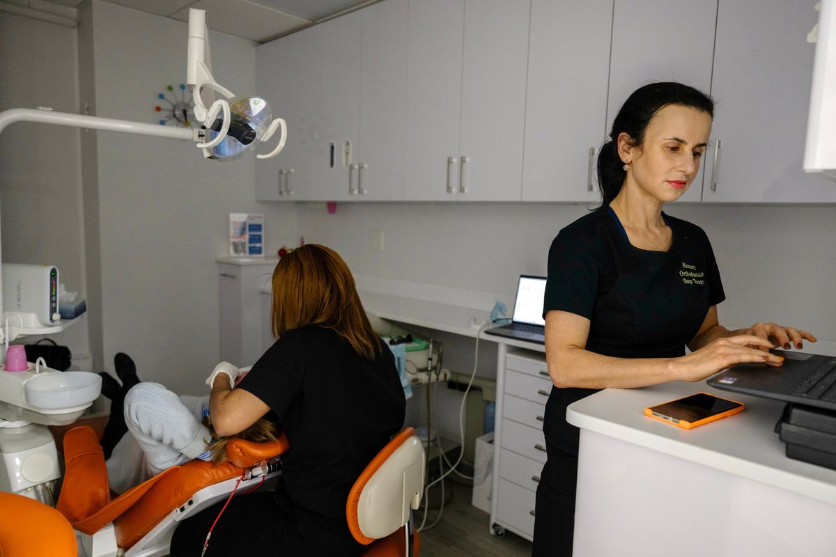 Dentist Maria Sokolina, right, works in the office she shares with two other dentists and an aesthetic medicine provider last year in New York City. Some physicians with independent practices are having to cobble together unconventional office arrangements at a time of rising costs and consolidation in the medical field. (New York Times)