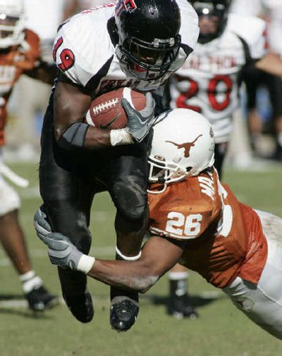 
Texas defender Marcus Griffin drags down Texas Tech running back Taurean Henderson during the second quarter in Austin, Texas, on Saturday. The Red Raiders piled up 455 yards on offense to the Longhorns' 444, but they couldn't keep up on the scoreboard.
 (Associated Press / The Spokesman-Review)