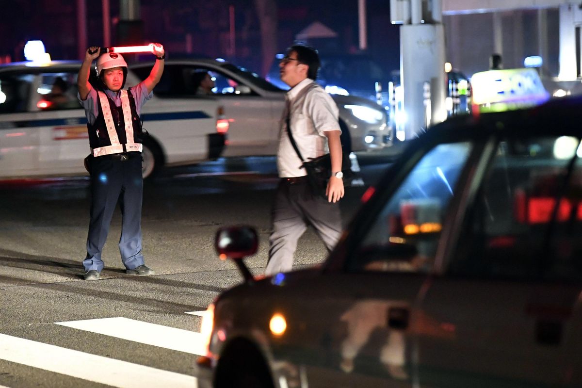 A police officer controls the traffic during a blackout following a strong earthquake in Sapporo, northern Japan early Thursday, Sept. 6, 2018. A powerful earthquake struck the island of Hokkaido early Thursday. (Yu Nakajima / AP)