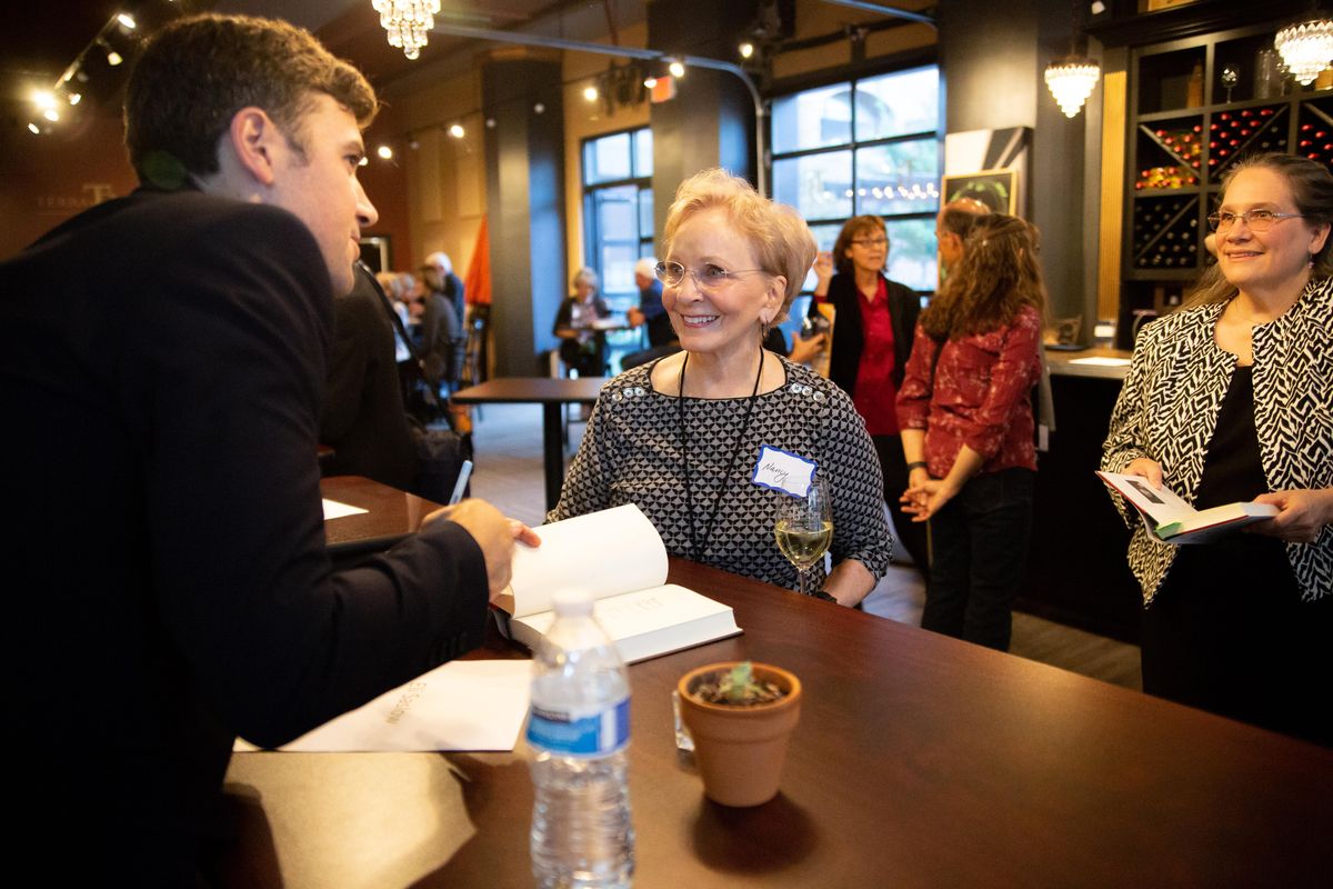Author Eli Saslow signs an autograph for Nancy James in Terra Blanca wine bar on Sept. 24, 2018. Saslow is a Pullitzer prize winner and spoke about his new book "Rising Out of Hatred" for a Northwest Passages Book Club event. (Libby Kamrowski / The Spokesman-Review)