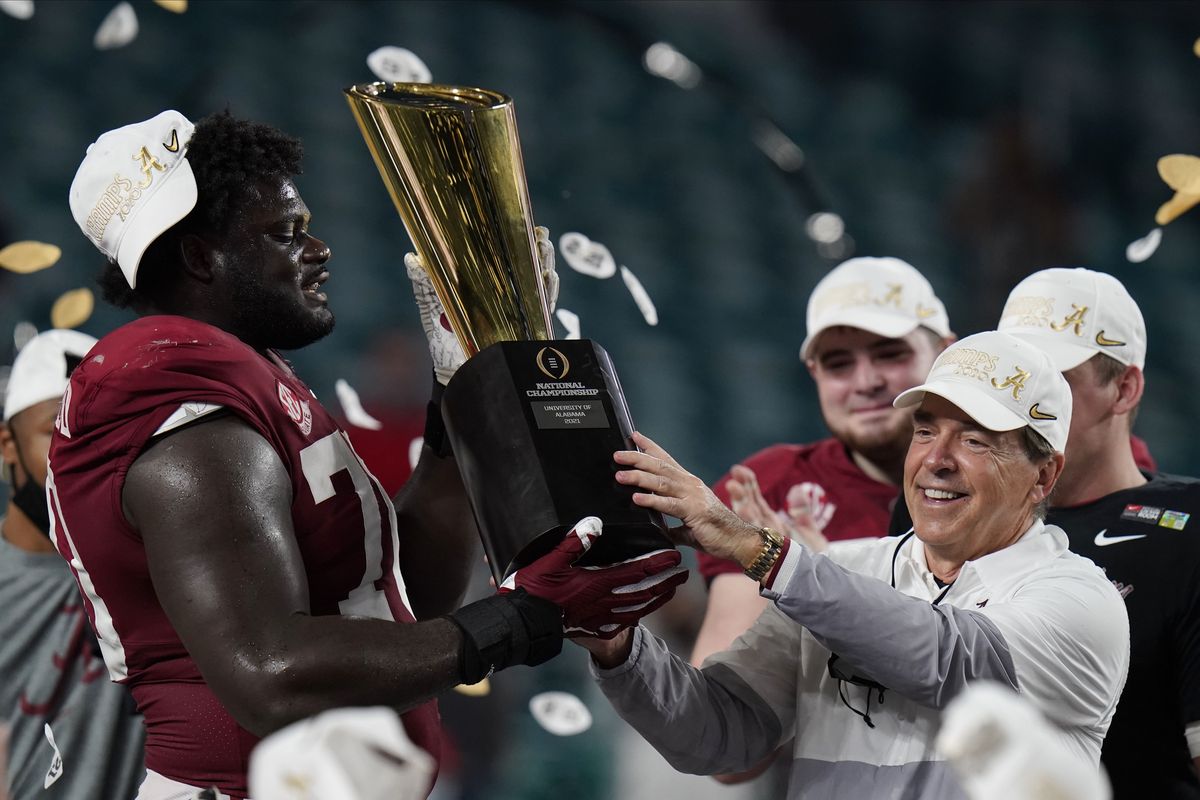 Alabama head coach Nick Saban and offensive lineman Alex Leatherwood hold the trophy after their win against Ohio State in an NCAA College Football Playoff national championship game, Tuesday, Jan. 12, 2021, in Miami Gardens, Fla. Alabama won 52-24.  (Chris O