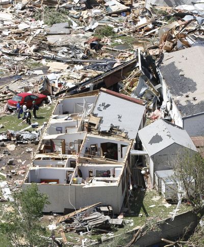 People examine tornado damage in in a Wichita, Kan., neighborhood on Sunday. (Associated Press)