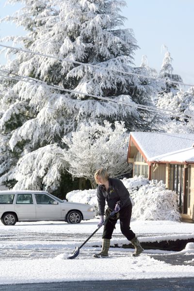 A clear path: Jamie Cox of the Franz Bakery Outlet shovels snow after a surprise snowstorm on Tuesday in Bremerton, Wash. (Associated Press)
