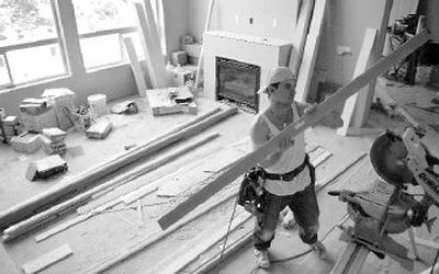 
Joey Lombard, a finish carpenter apprentice for Kiely Moore First Class Finish Carpentry, cuts trim work for a new Sullivan Homes Inc. house at the 17000 block of Rosemont Road in Spokane Valley. Sullivan Homes has been instrumental in the majority of the development going on in the area. 
 (Ingrid Lindemann / The Spokesman-Review)