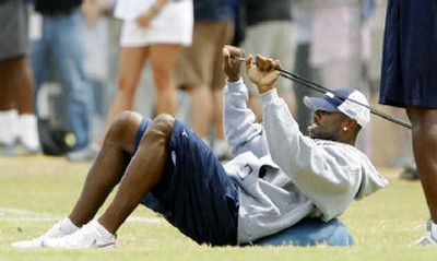 
Sidelined by a sore left hamstring, Dallas Cowboys receiver Terrell Owens stretched during Thursday's practice. 
 (Associated Press / The Spokesman-Review)
