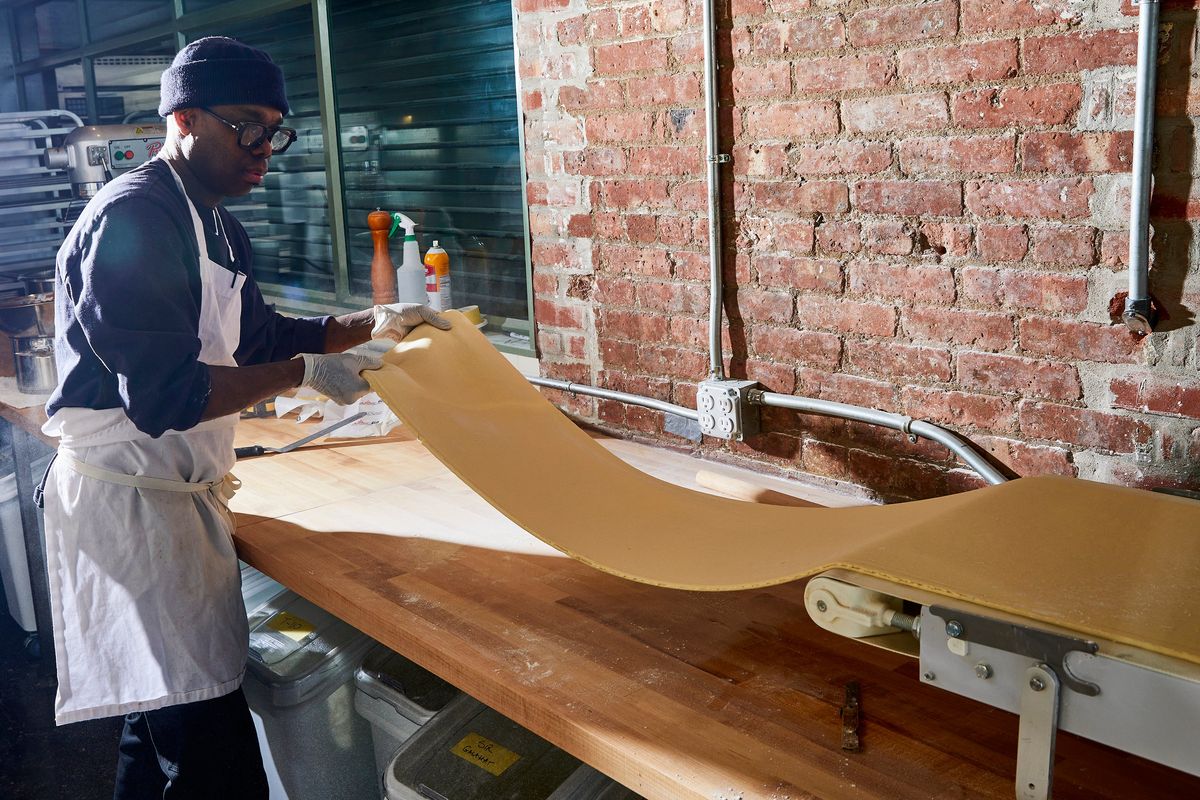 Baker Amadou Ly, who specializes in lamination, the exacting process that transforms butter, flour and yeast into a supple, silky dough, in Alf Bakery in New York on March 13, 2023. Ten years after the Cronut, croissants are still taking on new shapes, sporting swirls and stripes and drawing crowds.  (JULIA GARTLAND/New York Times)