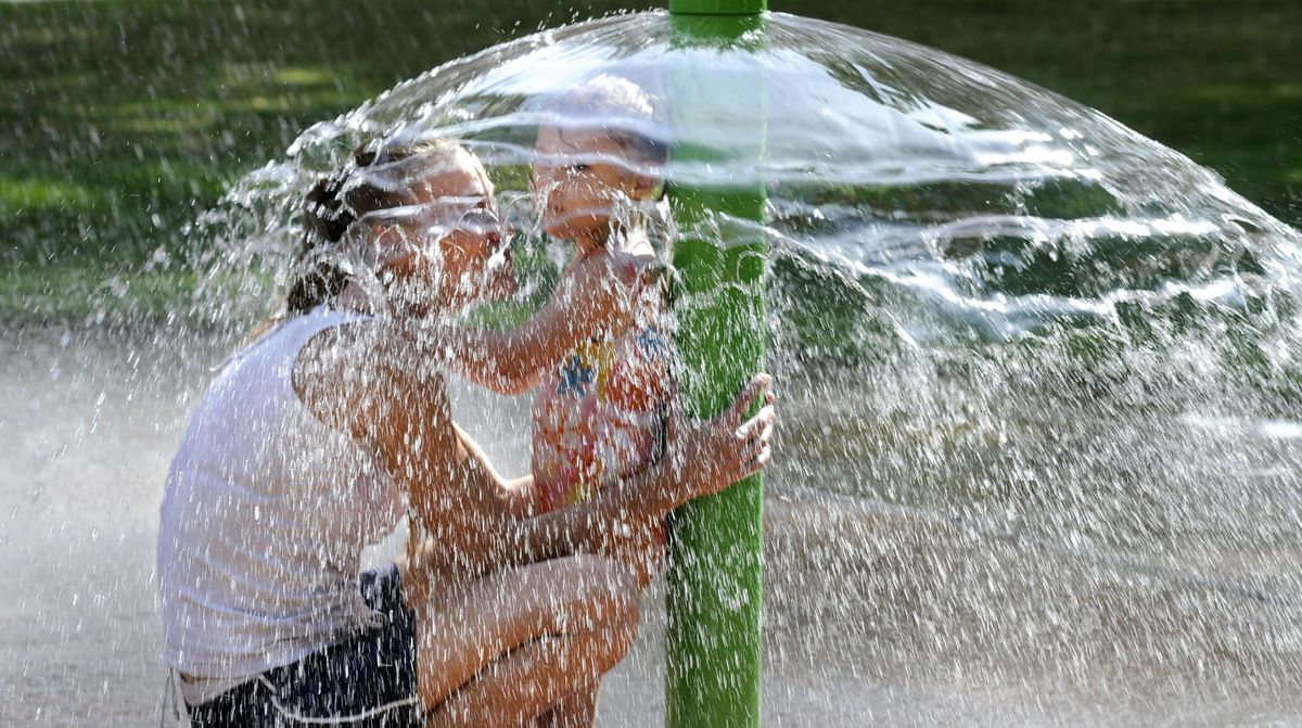 In this Aug. 28, 2009 photo, Vanessa Johnson and her daughter, Harmony Ritchie cool their heels under a mushroom-shaped fountain spray at the splash pad in Coeur d' Alene Park in Spokane's Browne's Edition. Johnson and friends said it was too cold to swim in their nearby apartment's pool because it had been filled with cold water from a garden hose. So the splash pad was just right on a day when temps climbed into the high 90s.  (DAN PELLE/THE SPOKESMAN-REVIEW)