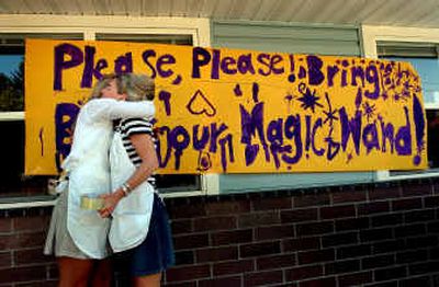 
Teacher Jaime Stephens, left, hugs Pam Pereira at Kinder-Magic on Monday after they hung a sign asking for the safe return of the magic wand that was stolen over the weekend.  
 (Kathy Plonka / The Spokesman-Review)