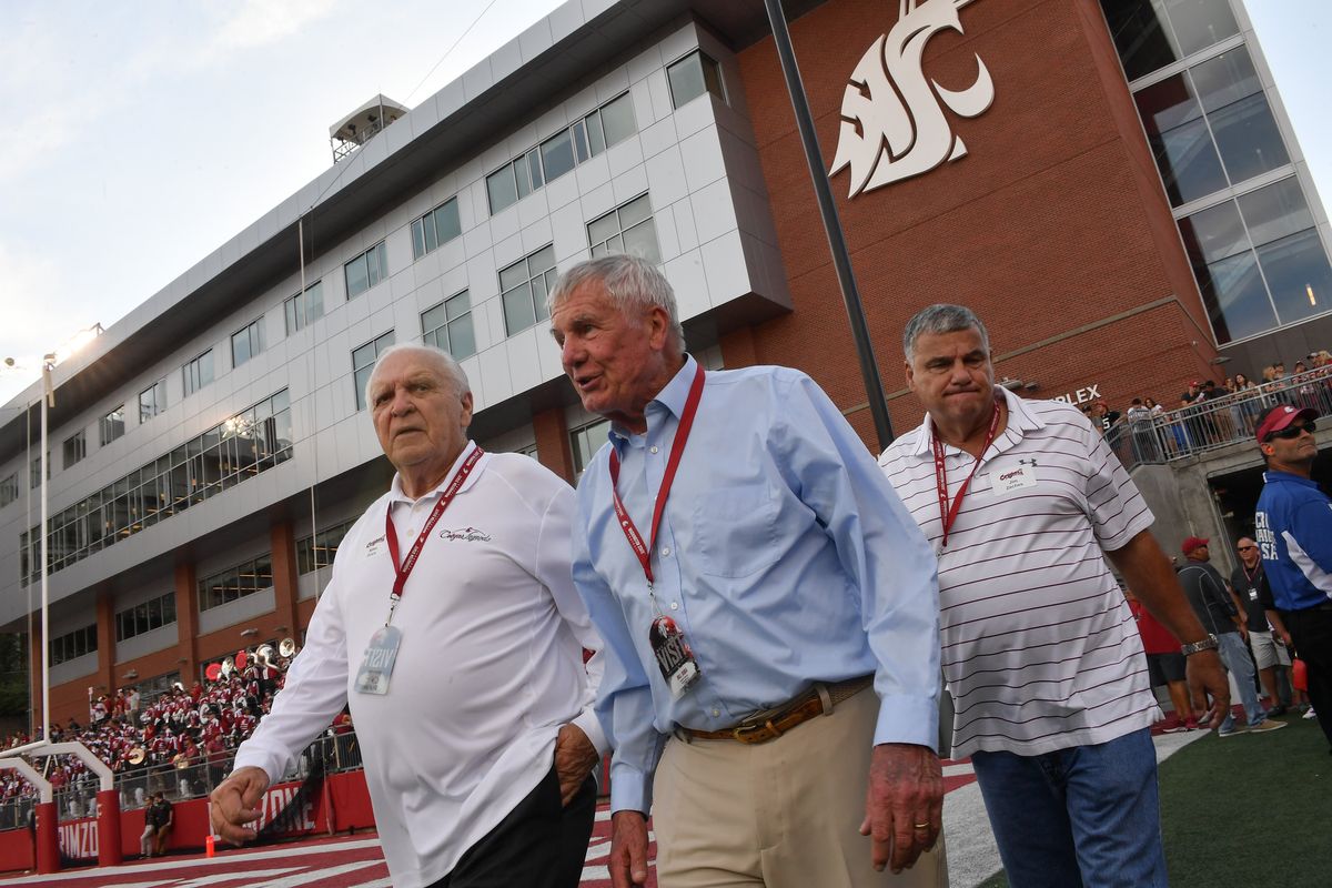 Former Washington State coaches Mike Price, left, and Bill Doba, center, walk on Gesa Field during the first half of Saturday’s homecoming game against California.  (Tyler Tjomsland/The Spokesman-Review)