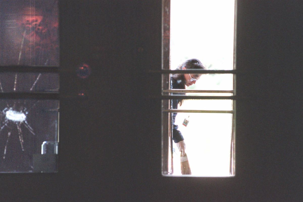 An agent with the Federal Bureau of Alcohol, Tobacco, Firearms and Explosives collects bomb debris evidence in the doorway outside Spokane City Hall on April 29, 1996. The blast, which occurred in the early morning hours, did not injure anyone. Federal investigators later implicated Danny L. “Cyclops” Lee, 46, in connection with the bombing. (Colin Mulvany / The Spokesman-Review)