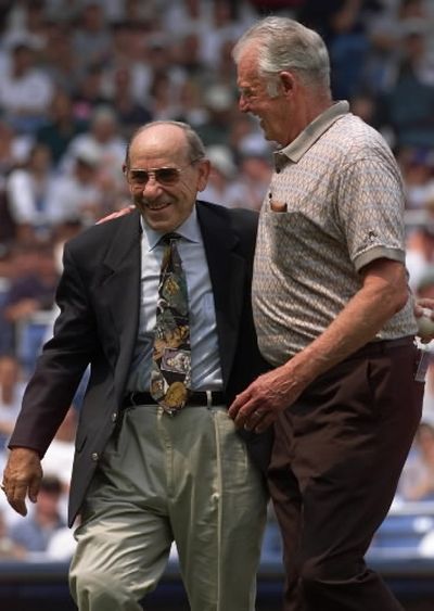 Yankee legend and catcher Yogi Berra, left, walks off the field arm in arm with former teammate Don Larsen, now of Hayden, after catching the ceremonial first pitch from Larsen before the New York Yankees game against the Montreal Expos during 
