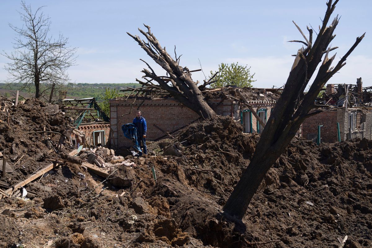 People stand in destroyed residential area after Russian airstrike in Bakhmut, Donetsk region, Ukraine, Saturday, May 7, 2022.  (Evgeniy Maloletka)