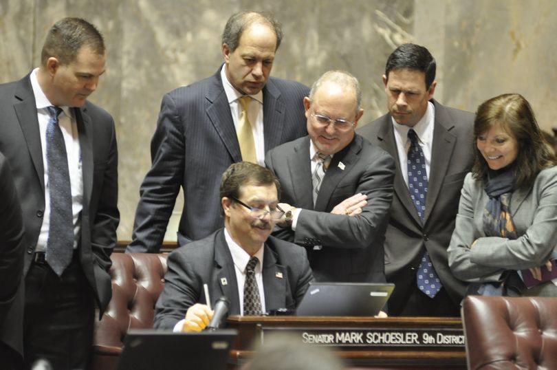OLYMPIA -- Members of the Majority Coalition Caucus -- Sens. Steve Braun, Steve O'Ban, Mike Hewitt, Andy Hill and Sharon Brown, standing, from left -- monitor the vote count on an alcohol sales tax bill over over Sen. Mark Schoesler's shoulder. The coalitions's measure passed. (Jim Camden)