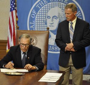 OLYMPIA -- Gov. Jay Inslee signs a bill delaying parts of Initiative 1351 while Davenport School Superintendent Jim Kowalkowski looks on, on July 14, 2015. (Jim Camden/Spokesman-Review)