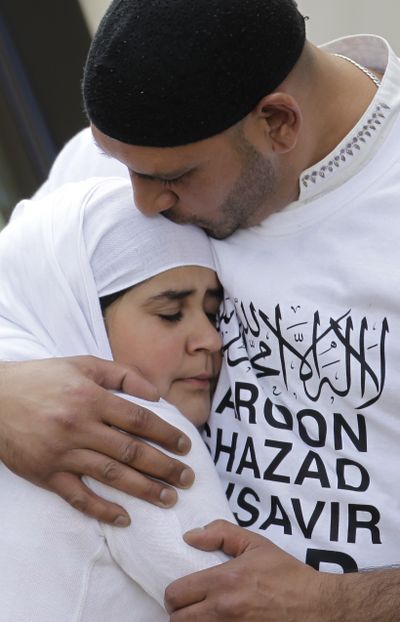 Family members grieve during the Aug. 18 funeral service in Birmingham, England, for three men killed in a hit-and-run attack during the riots. (Associated Press)