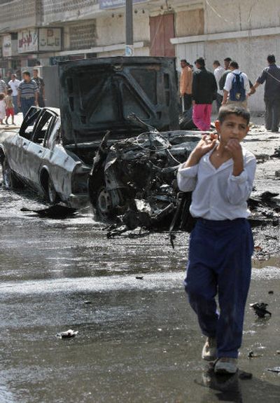 
A schoolboy walks past the aftermath of a car bomb attack in Baghdad on Tuesday. 
 (Associated Press / The Spokesman-Review)