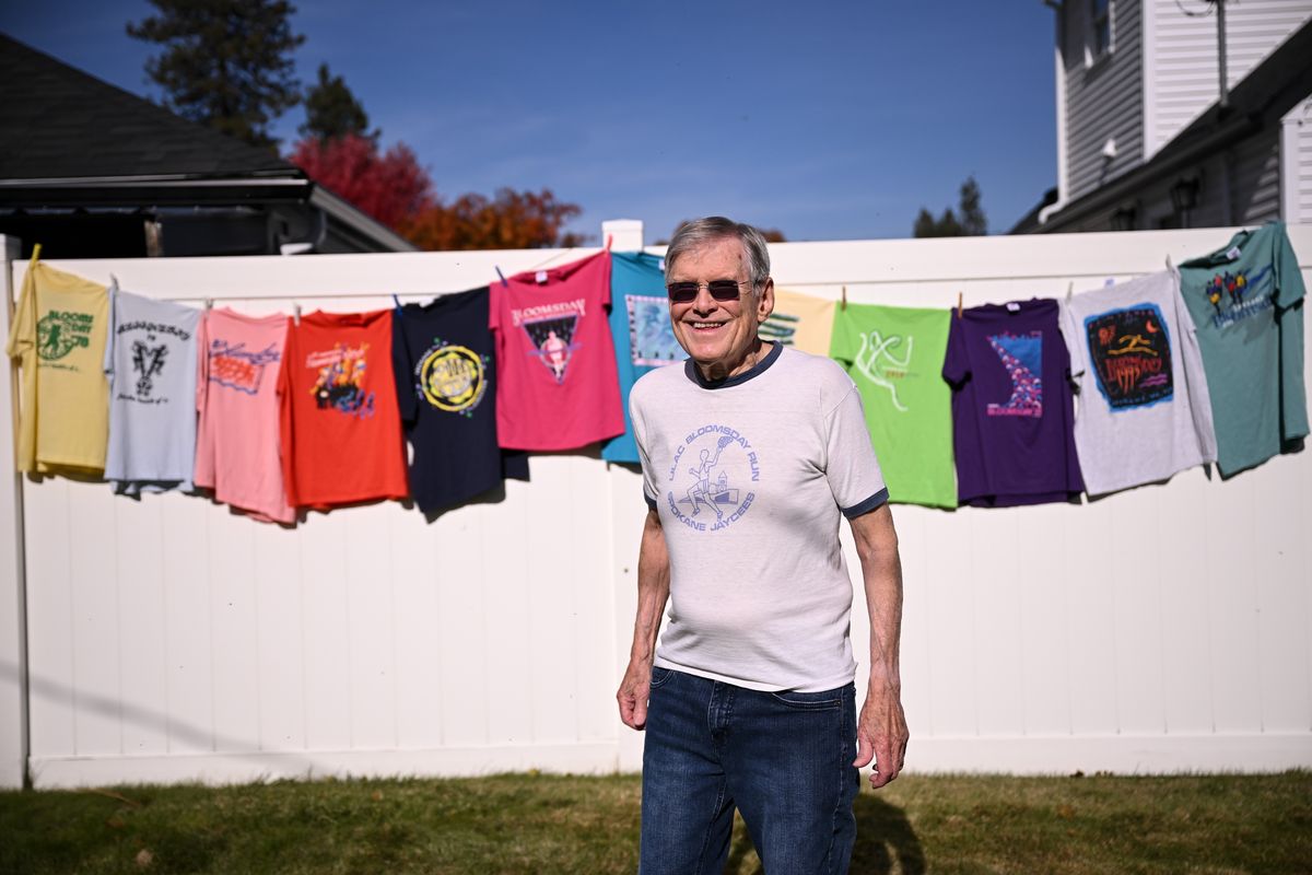 Bloomsday Perennial Ken Hill shows off a small collection of his favorite finisher T-shirts recently at his home in Spokane. (Tyler Tjomsland/The Spokesman-Review)