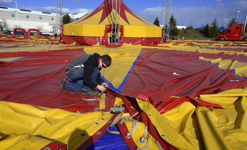 Circus worker Daniel Green laces up the big tent Monday in the parking lot of the Spokane Valley Mall. The Shrine Circus, in its 59th year in Spokane, opens today. (Colin Mulvany)