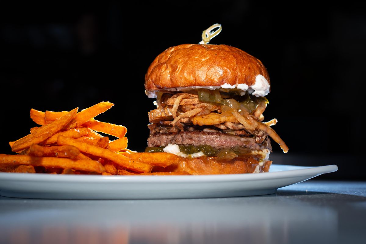 The jalapeno mushroom burger goes for $15 at RÜT Bar and Kitchen and contains an Impossible burger patty, tempeh bacon, sauteed mushrooms, crisped onions, cream cheese and jalapeno relish on a pretzel bun, as photographed with sweet potato fries on April 15, 2019. The gastropub opened last Monday, April 8 in the South Hill District and is located at 901 W. 14th Avenue. (Libby Kamrowski / The Spokesman-Review)