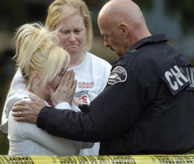 A relative of the deceased children is comforted by a Pierce County sheriff’s deputy  Saturday.  (Associated Press / The Spokesman-Review)