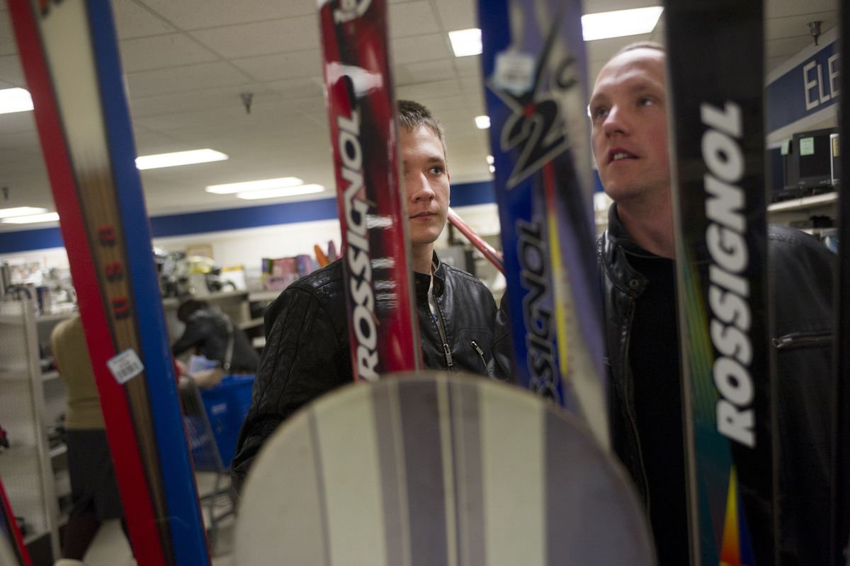 Dennis Bondarenko, left, checks out skis with his brother Alex at the Goodwill store on Third Avenue.