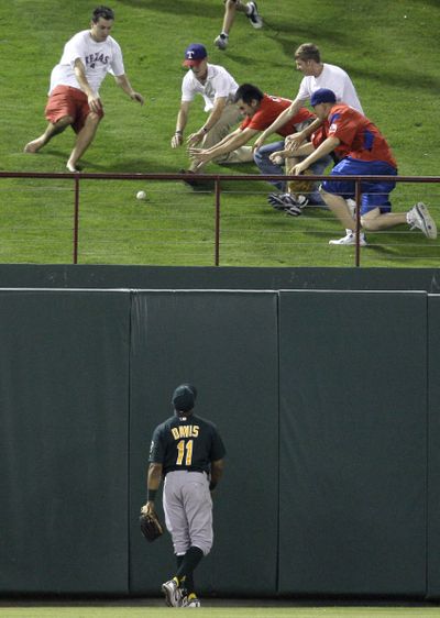 Oakland Athletics center fielder Rajai Davis (11) looks up as fans scramble for a solo home run ball by Texas Rangers' Max Ramirez in the sixth inning of a baseball game, Wednesday, May 12, 2010, in Arlington, Texas. The solo shot came off of Chad Gaudin in the 10-1 Rangers win. (Tony Gutierrez / Associated Press)
