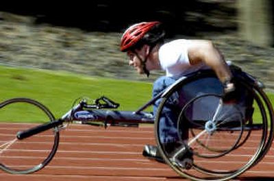 
After being fitted for a racing wheeling chair, Lance Sutterlin gives it a spin for the first time around the Whitworth College track. 
 (Colin Mulvany / The Spokesman-Review)