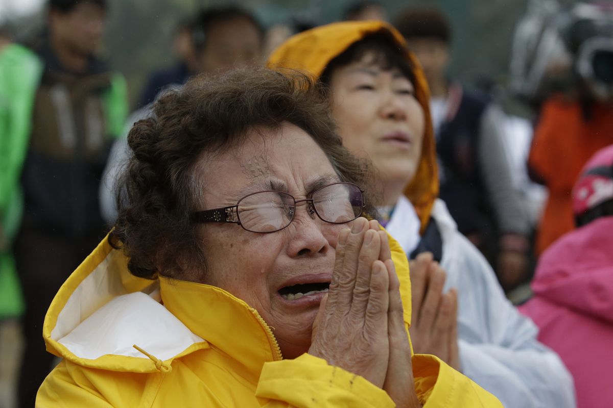 Relatives of passengers aboard a sunken ferry cry and pray during a Buddhist ceremony in Jindo, south of Seoul, South Korea, today. (Associated Press)