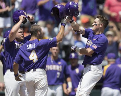 LSU's Michael Papierski, right, celebrates with Josh Smith (center) and Beau Jordan after hitting a three-run home run against Oregon State at the College World Series Saturday in Omaha, Nebraska. LSU won 6-1 to advance to the championship series. (Ryan Soderlin / Associated Press)