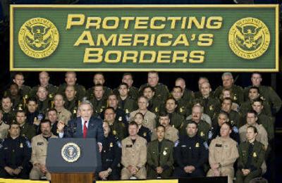 
President Bush speaks about immigration at Davis Monthan Air Force Base in Tucson, Ariz., on Monday as Border Patrol and Immigration officers and employees stand in the background. 
 (Associated Press / The Spokesman-Review)