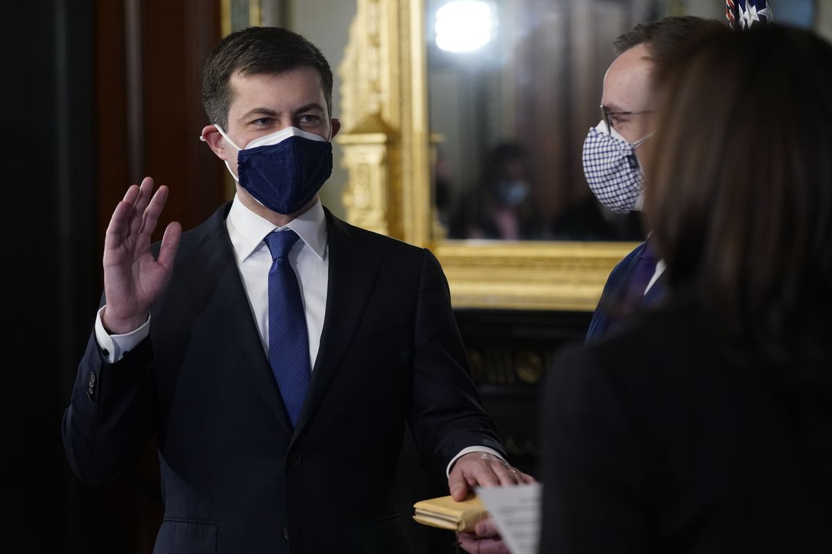 Pete Buttigieg, with his hand on the Bible held by Chasten Buttigieg, is sworn in as Transportation Secretary by Vice President Kamala Harris in the Old Executive Office Building in the White House complex in Washington, Wednesday, Feb. 3, 2021.  (Andrew Harnik)