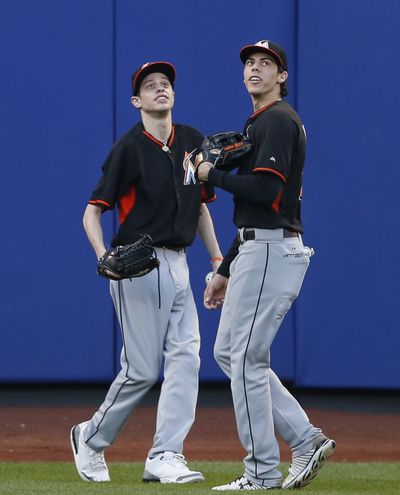 Miami’s Christian Yelich, right, and comedian Pete Davidson, shag flies during BP. (Associated Press)