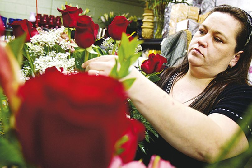 Danielle Hansen, owner of Hansen's Florist and Gifts, prepares one of the hundreds of pre-ordered Valentine's Day floral arrangement Monday at her storefront in Coeur d'Alene. (Jerome Pollos/press)