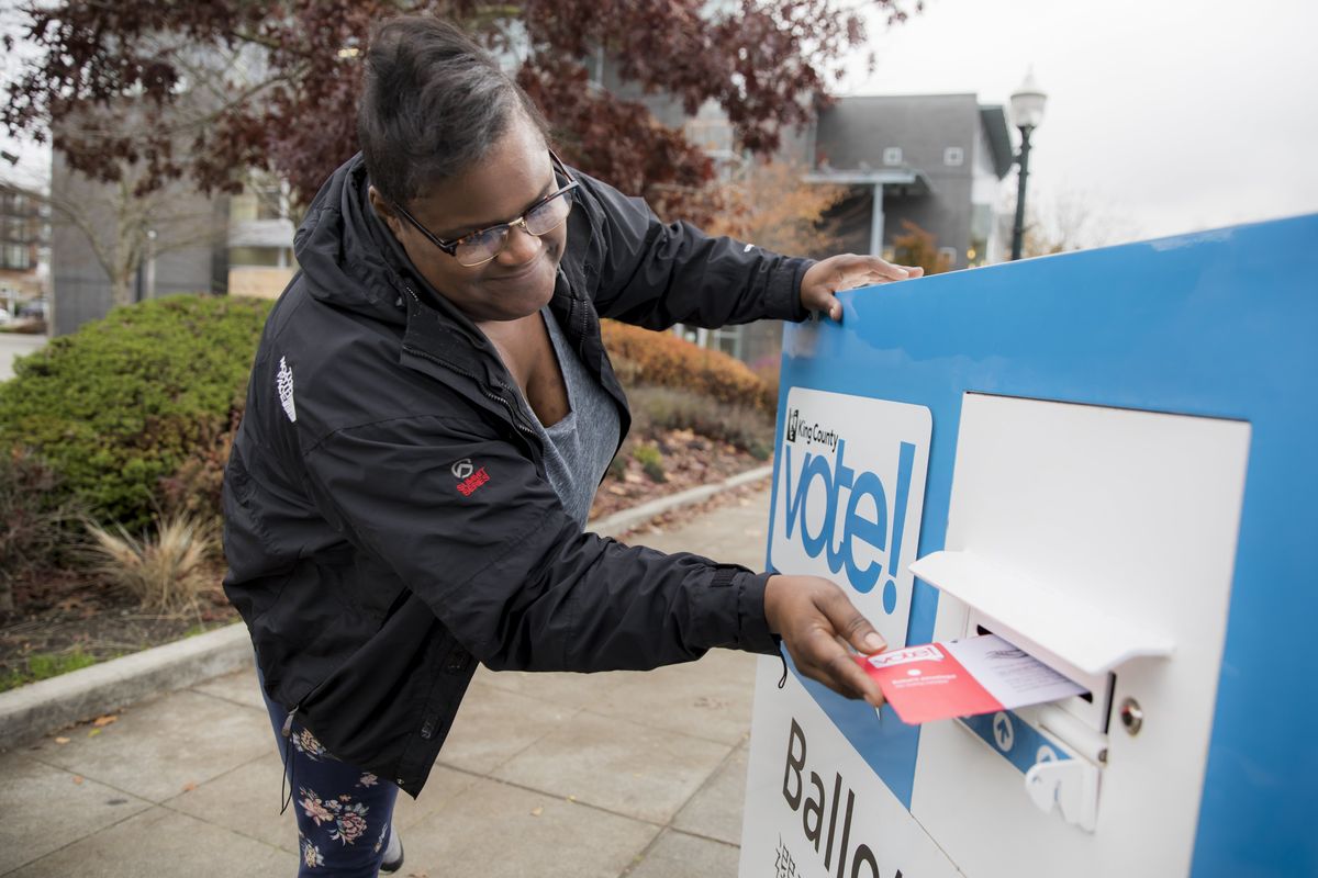 Sherita Cooks drops her ballot in a King County Elections ballot drop box on Election Day for the midterms on Nov. 6, 2018, in Burien, Wash.  (Bettina Hansen/The Seattle Times via AP)
