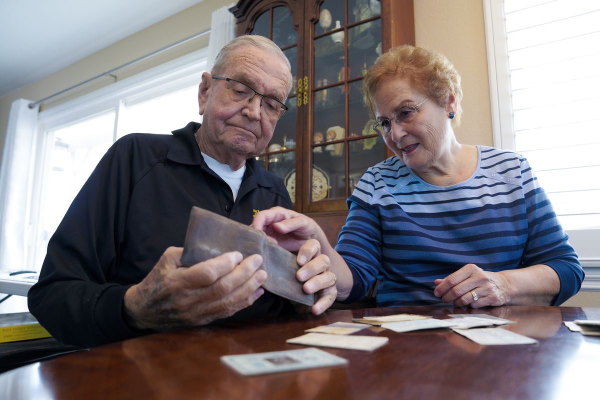 Paul Grisham and his wife Carole Salazar look over his wallet and the items that were inside when he lost the wallet back in 1968 at their home in the San Carlos section of San Diego, Calif., Wednesday, Feb. 3, 2021. Grisham’s wallet was missing for so long he forgot all about it. Fifty-three years later, the 91-year-old has the billfold back along with mementos of his 13-month assignment as a Navy meteorologist on Antarctica in the 1960s.  (Nelvin C. Cepeda)