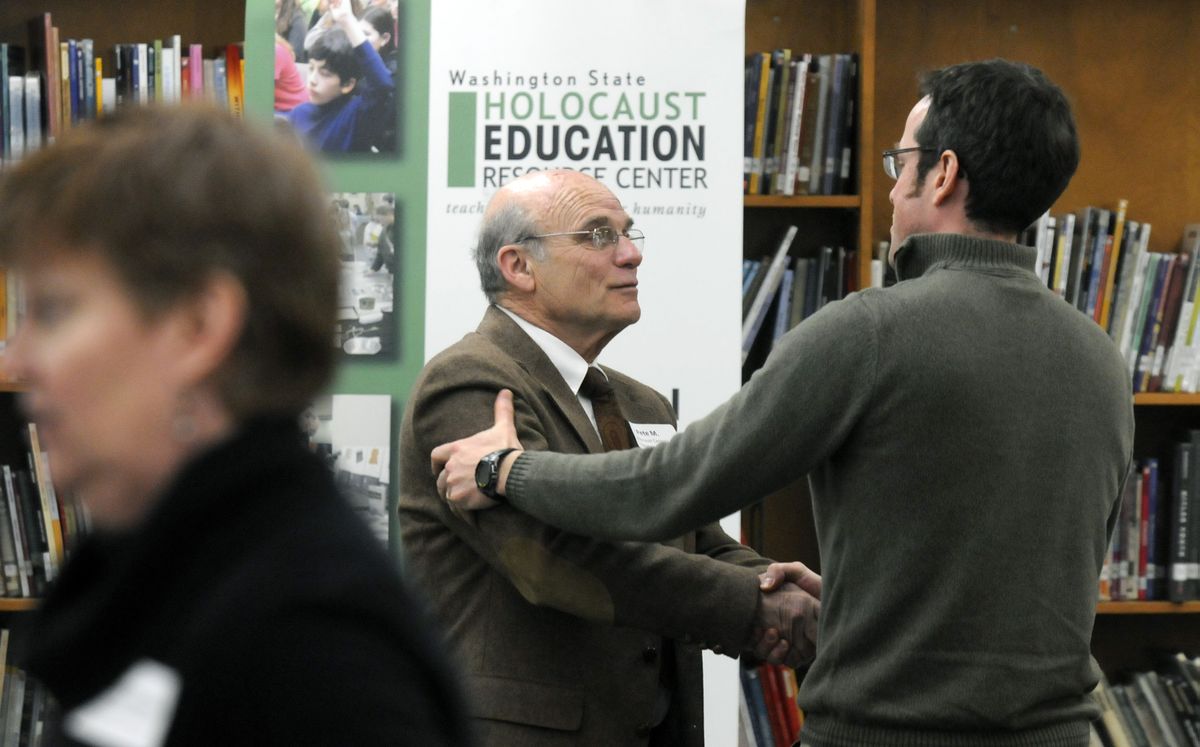 Peter Metzelaar, center, a Holocaust survivor, is thanked by Alexander Allison, a teacher from Alaska, after Metzelaar spoke about his experiences to a classroom of middle school instructors Friday at East Valley Middle School in Spokane Valley.  (Photos by Dan Pelle / The Spokesman-Review)
