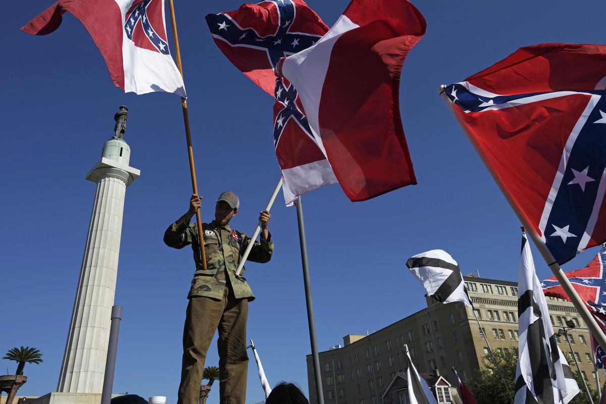 A protester advocating for the preservation of Confederate monuments in New Orleans holds Confederate battle flags, Sunday, May 7, 2017, in New Orleans. Protesters calling for the removal and the preservation of Confederate-era monuments faced off in dueling demonstrations Sunday at a memorial honoring Confederate Gen. Robert E. Lee. The statue is one of three memorials to Confederate-era figures the city plans to take down. Another memorial has already been removed. (Max Becherer/The Advocate via AP) (Max Becherer / Associated Press)