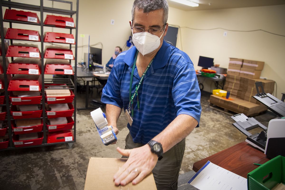 Elections Manager Mike McLaughlin seals up one of the hundreds of boxes of ballots after they’ve been counted as his office counts the last of the ballots from Spokane County, Friday, Nov. 6, 2020, at the Spokane County Elections Office.  (Jesse Tinsley/The Spokesman-Review)