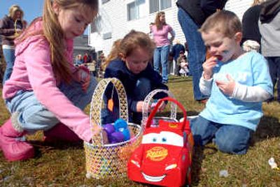 
Daisha Wright, 6, Brianna Wright, 4, and Christian Wright, 2, look in their plastic eggs for prize certificates after an egg hunt Saturday at the Loyalton assisted living center  in Coeur d'Alene. 
 (Jesse Tinsley / The Spokesman-Review)