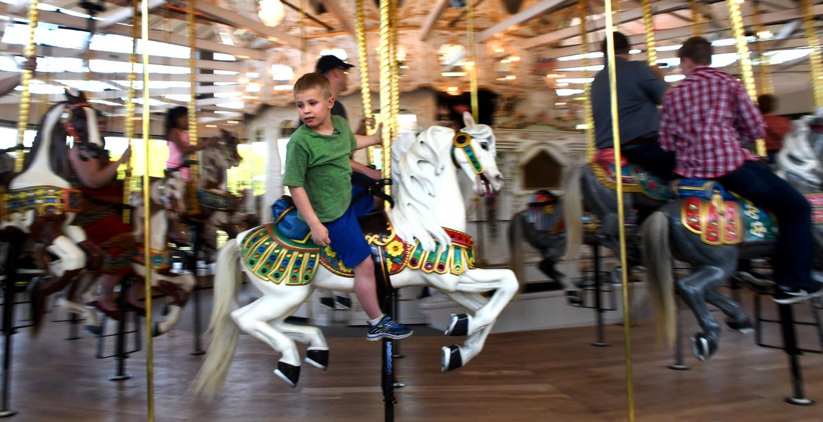 Eight-year-old Eli Kenagy rides the Looff Carrousel during the grand opening in Spokane on Saturday, May 12, 2018. (Kathy Plonka / The Spokesman-Review)
