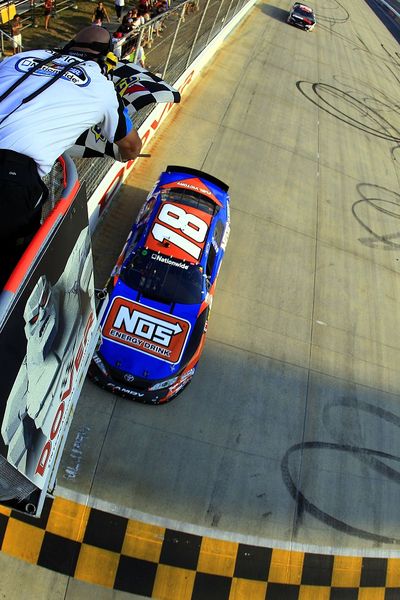 Kyle Busch, driver of the No. 18 NOS Toyota, crosses the finish line to get his third win and either top-10 finish in 13 races at Dover International Speedway. (Photo courtesy Chris Trotman/Getty Images) (Chris Trotman / Getty Images North America)