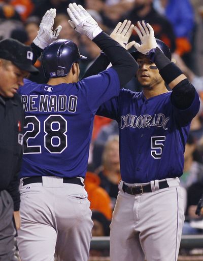 Rockies 3B Nolan Arenado, left, is greeted at the plate by Carlos Gonzalez after hitting the first of his two home runs – a three-run shot in the sixth inning – in San Francisco on Friday. (Associated Press)