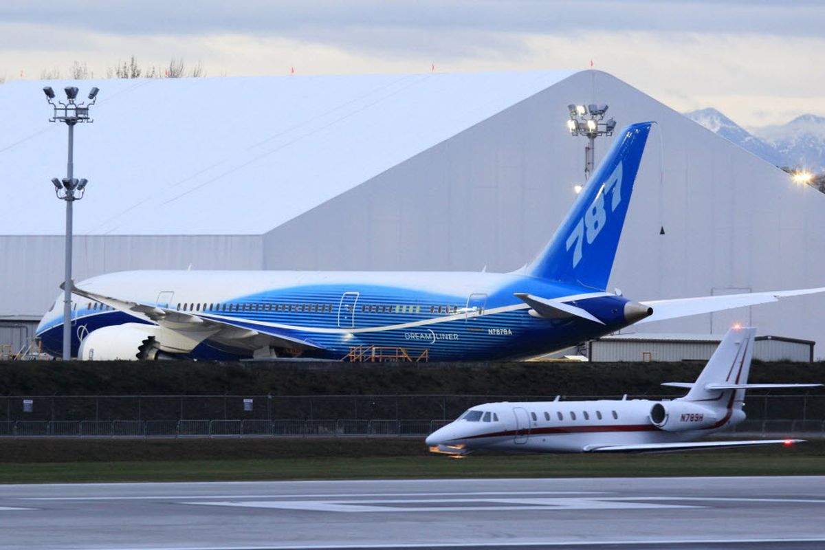 The first production Boeing 787 airplane is parked behind a smaller plane at Paine Field in Everett, Wash., at dusk Monday, Dec. 14, 2009. Weather permitting, Boeing plans to finally get its new 787 jetliner into the air Tuesday, more than two years after it had intended. (Associated Press)